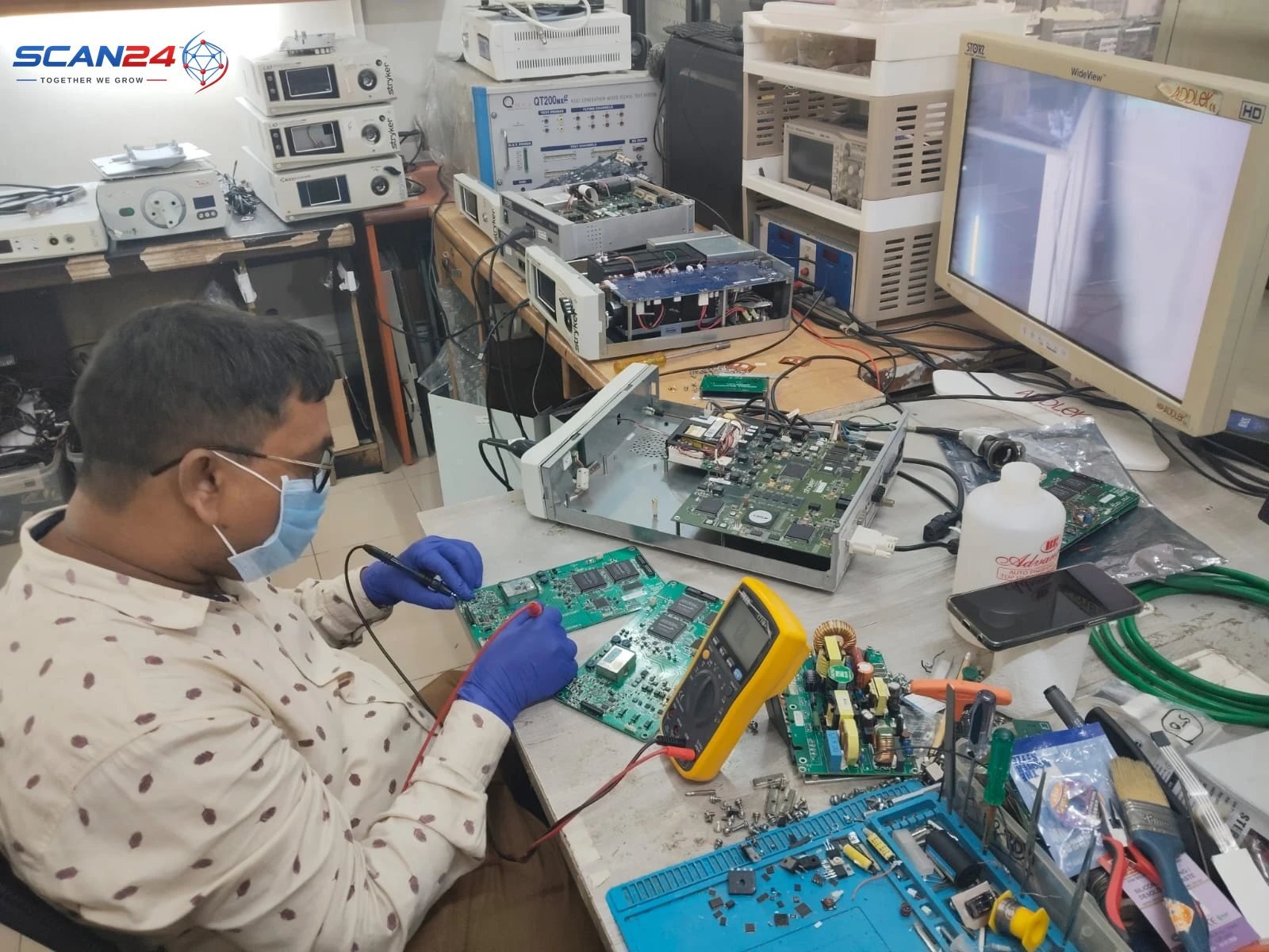 SCAN24 technician testing OT equipment electronics at the in-house repair centre, part of preventive maintenance under an AMC
